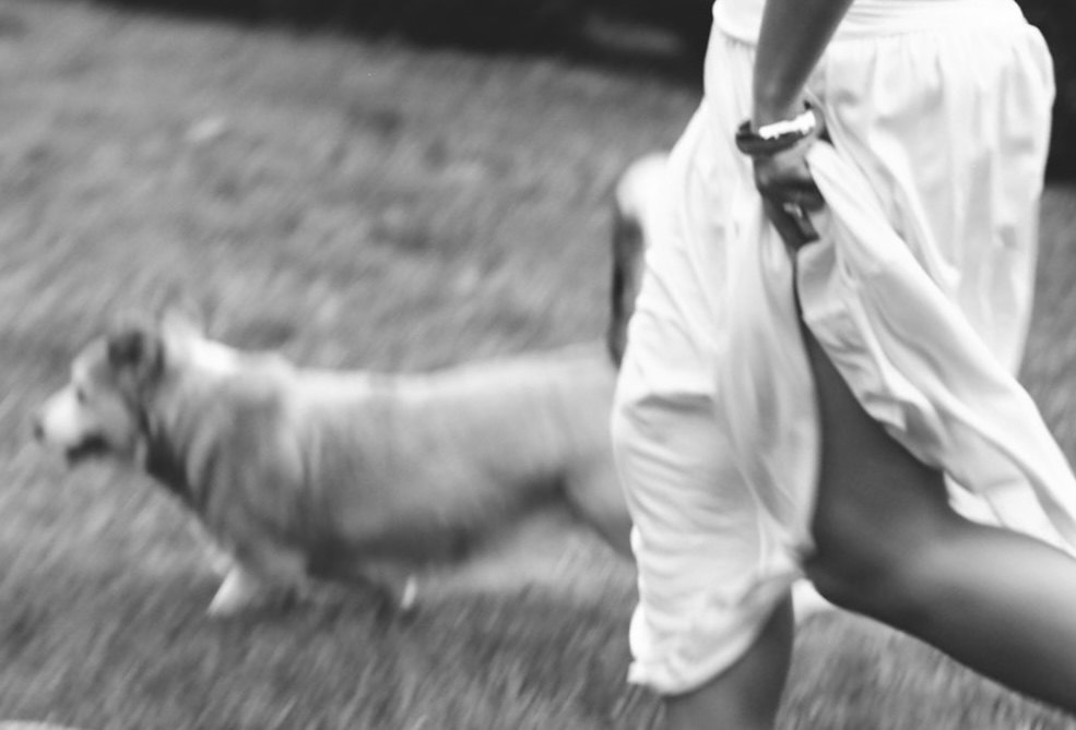 Davis Shiflett running across a lawn with her dog Scout, in black and white